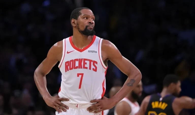 Kevin Durant stands with his hands on his hips in a white Houston Rockets jersey during a game.
