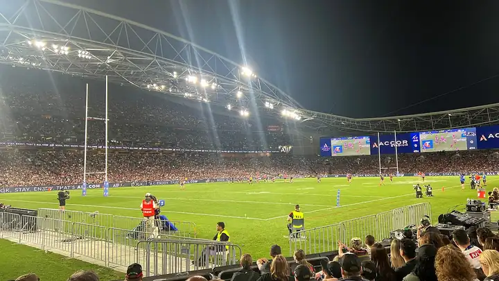 A packed Accor Stadium under floodlights during a night rugby league match