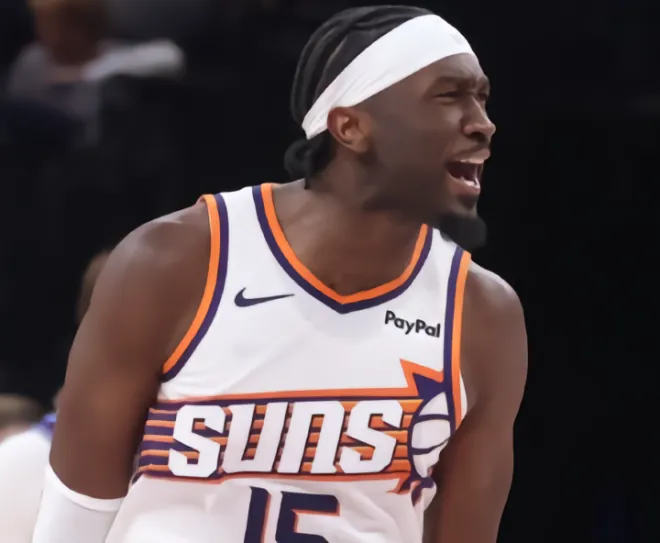 Phoenix Suns centre Mark Williams shouting during a game in a white Suns number 15 jersey.